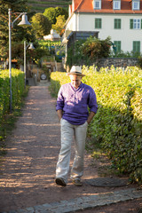 Man in hat slowly walks vineyard countryside