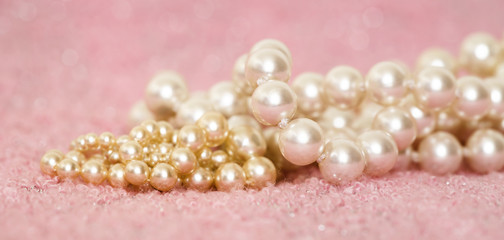 Website banner of woman jewelry gift, white and golden pearls on pink background
