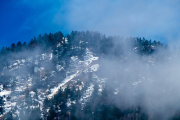 Wolkenschleier vor schneebedecktem Berg