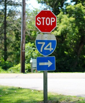 A stop sign and a interstate sign at the intersection of road.