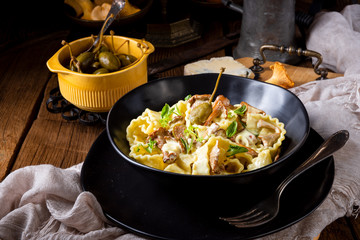 Reginette noodles in cream sauce with fresh chanterelles and capers