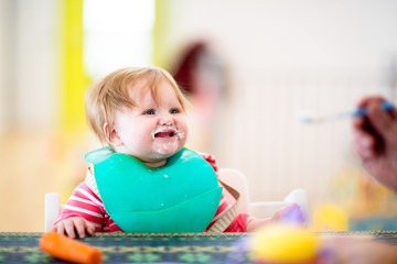 Fototapeta premium 8 month old girl eating dinner