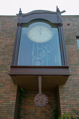 Big outside clock with visible mechanism and moon and sun wooden carved  figure. Torun, Poland