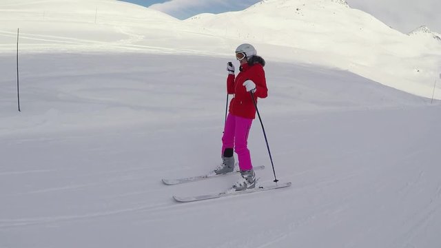 Happy Woman Skier Skiing Down On The Slope In Winter And Dancing With Her Hands