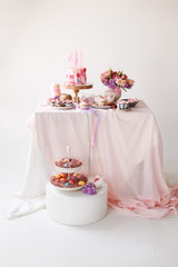  A festive table with desserts of pink color.  Easter table with different desserts and Easter eggs