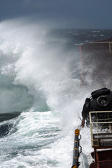 sea storm wave hits the side of the tanker