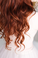  Long-haired girl with curly red hair. Hair falls from the shoulders. Hair up to priests.