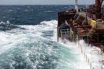 storm wave floods the deck of the ship