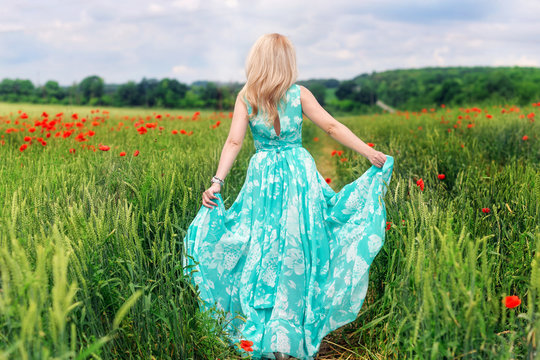 Little girl running away in a field whith poppy outdoors