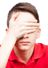 Teen boy shuts his eyes isolated on white