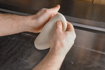 Fototapeta premium Hands of Chef preparing dough for italian pizza