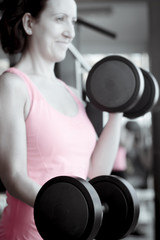 Fototapeta na wymiar Thin thirties woman doing exercise in the gym