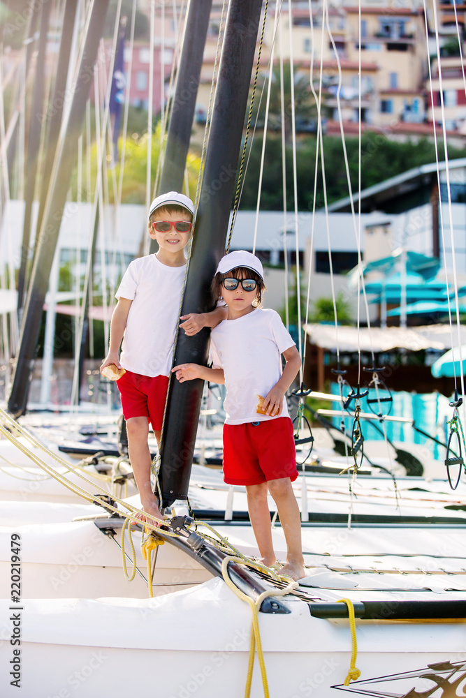 Sticker Two beautiful children, boy brothers, standing on a boat, smiling