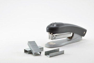 Stationery stapler and metal staples on white background.