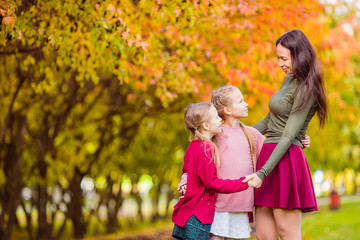 Fototapeta premium Little girl with mom outdoors in park at autumn day