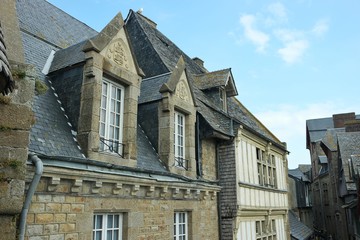 Fototapeta na wymiar Roofs of old houses and chimneys in the fortress Mont Saint Mishel, Normandy, France