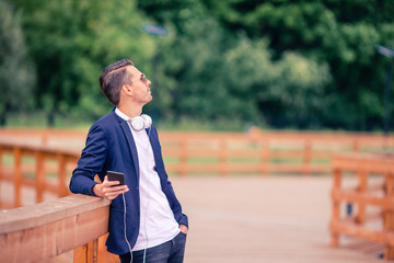 Happy young urban man drinking coffee in european city outdoors