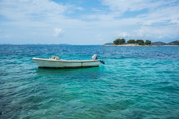 Naklejka premium Small boat floating on turquoise Adriatic Sea near Croatian island