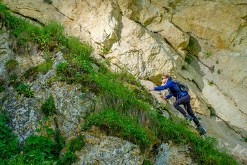 Girl mountaineer in the mountains. Climb to the mountain top.