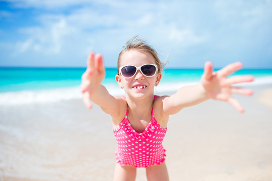 Happy little girl taking selfie at tropical beach on exotic island