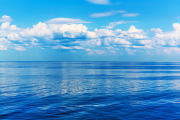 Blue sea or ocean and sky with clouds