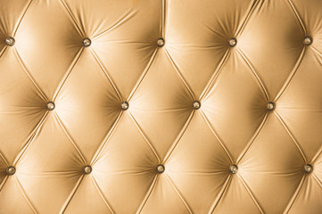 Beige soft textile background with symmetrical buttons on the corners of diamonds. Soft and expensive furniture elements. Luxury background
