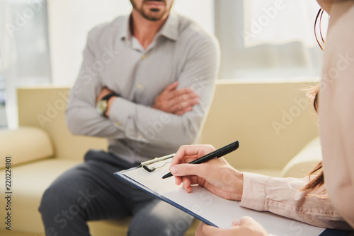 Cropped View Of Patient And Psychologist Writing Diagnosis In