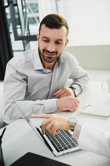 doctor showing something on laptop to male client in office