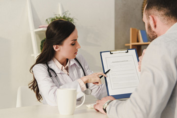 female doctor showing insurance claim form to client