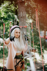 Teenage girl is having fun on a rope swing which she has found while hiking. Girl in a rope park. Rope park