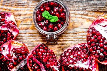 sliced pomegranate on wooden background top view