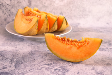Slices of orange cantaloupe melon on white plate