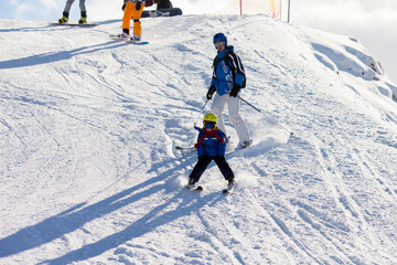 Fototapeta na wymiar Father and son, preschool child, skiing in austrian ski resort in the mountains
