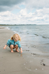 2 year old picking up a little jelly fish