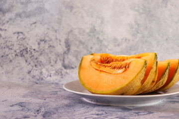 Slices of orange cantaloupe melon on white plate