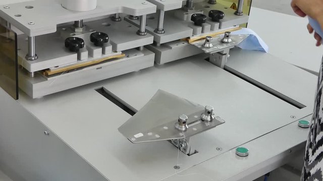a woman in the sewing shop on the press machine gives the shape of a shirt collar and cuffs