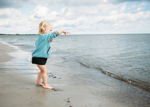 2 year old girl returning a jelly fish to the ocean