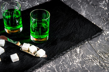 absinthe in glass on gray background close up