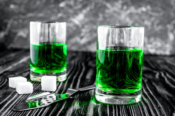 absinthe with sugar cubes and spoon on wooden background