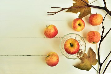 Naklejka na ściany i meble Autumn still life, ripe apples, fall leaves and twigs, copy space.