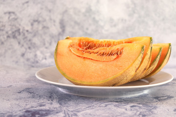 Slices of orange cantaloupe melon on white plate