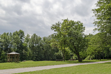 Wooden bench, alcove and table on a meadow in the forest at natural old West park, Sofia, Bulgaria  