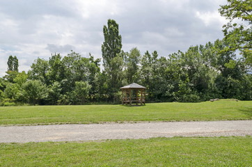 Wooden bench, alcove and table on a meadow in the forest at natural old West park, Sofia, Bulgaria  
