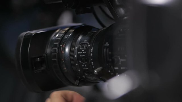 Camera operator working with a cinema broadcast TV camera. Back view