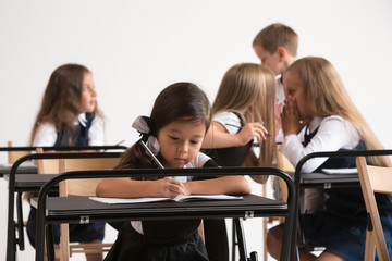 School children in classroom at lesson. The little boys and girls sitting at desks. Back to school, education, classroom, lesson, learn, lifestyle, childhood concept