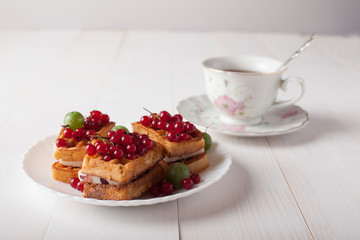 Viennese waffles with berries and a cup of tea stand on the table