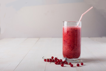 fresh smoothies of red currant in a glass stands on a white table