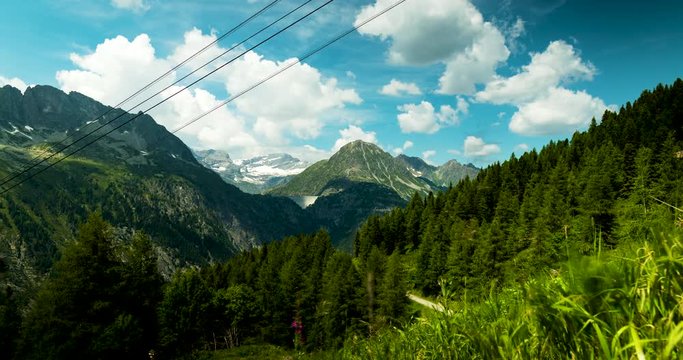 footage of the mont blanc massif near chamonix in the french alps showing clouds moving against blue summer sky and green alpine meadows