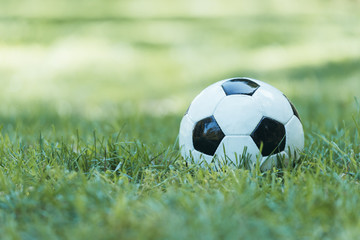 Fototapeta premium close-up view of leather soccer ball on green grass