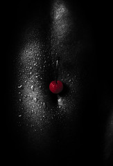 Red cherry on a black body. Sexy African-American woman. Seductive and attractive dark skin. Black and white photo. Passion and temptation, sex with a woman. Beautiful body after training, fitness - 220231059